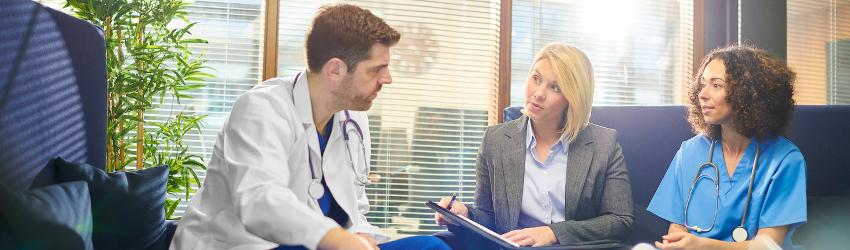 Healthcare administrator speaking with a doctor and a nurse